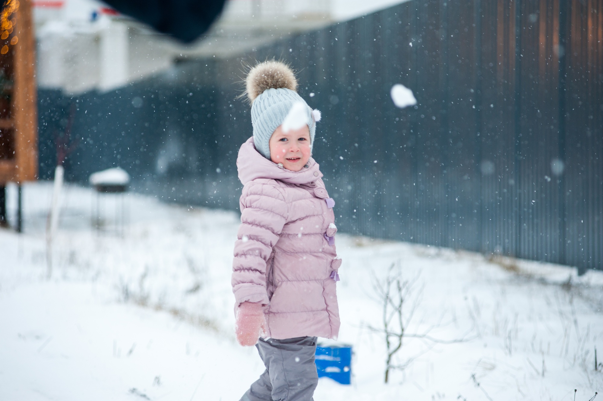 child girl playing outside in winter in the snow