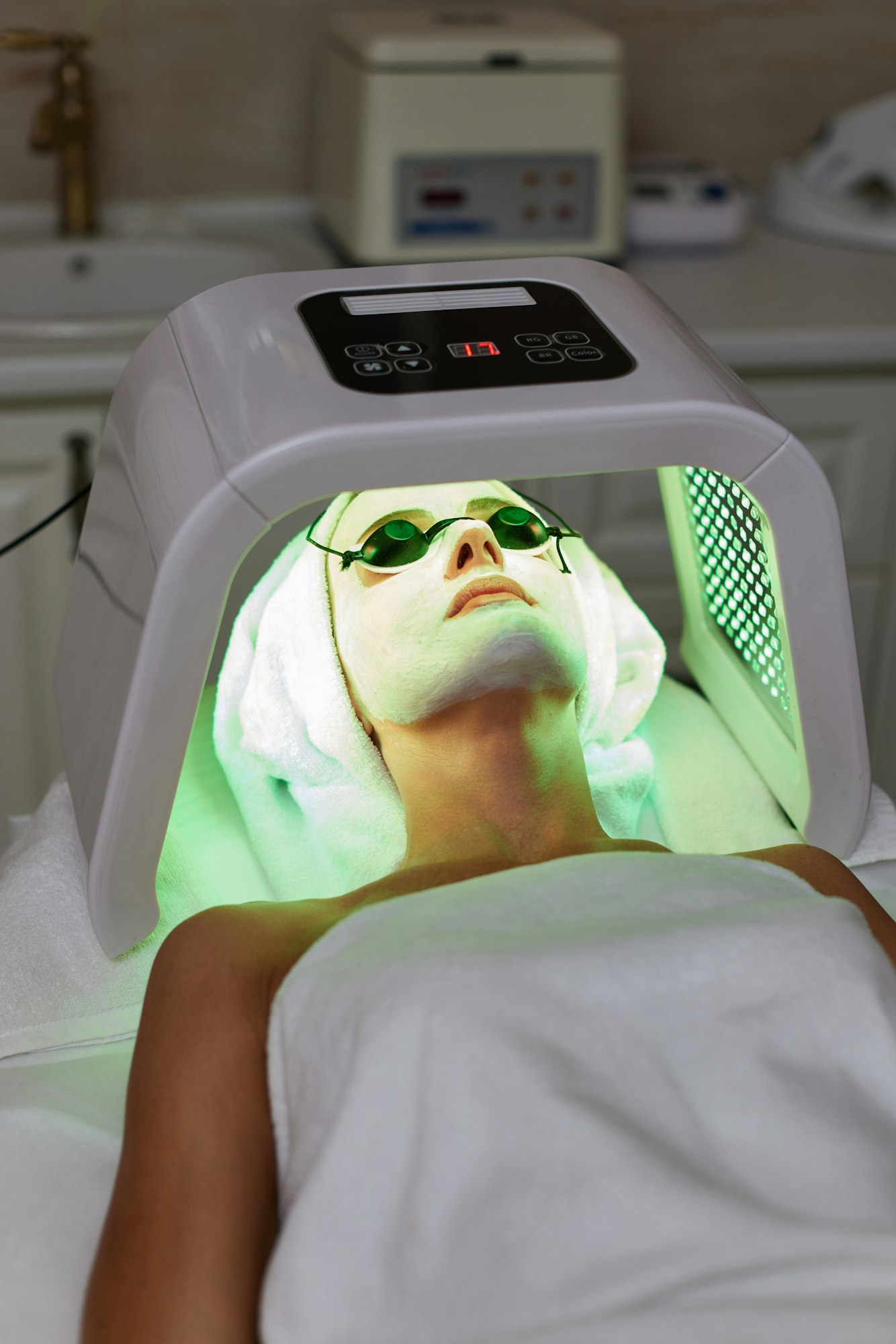 Woman getting facial treatment with led therapy.